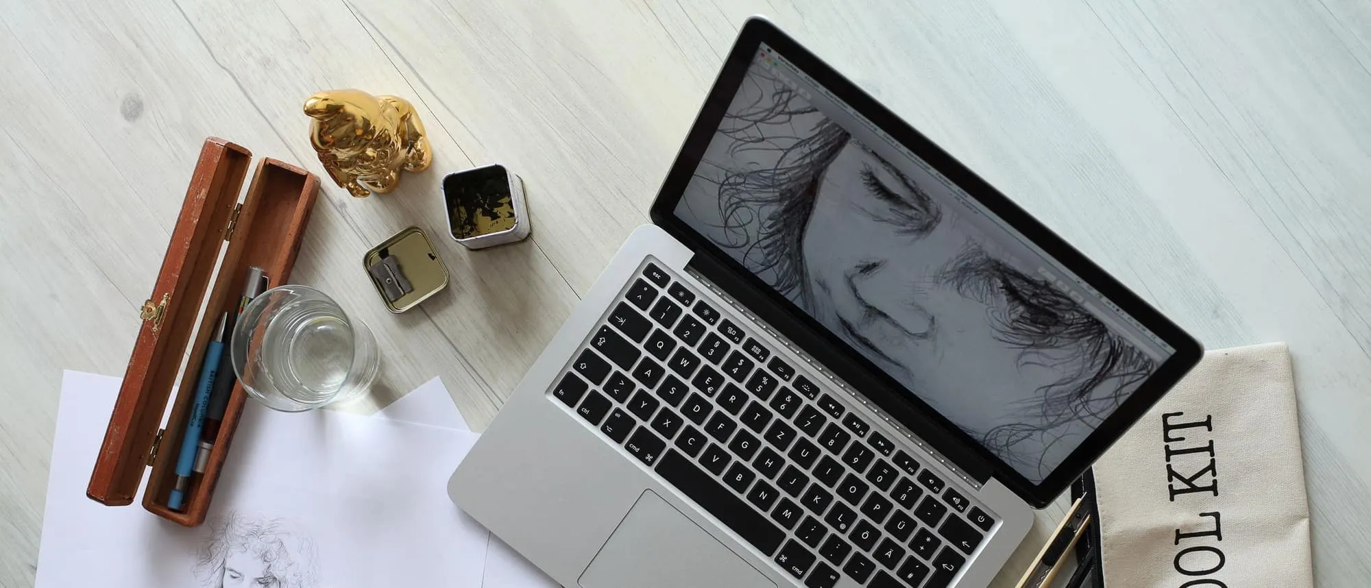 A creative workspace seen from above with sketches and a laptop