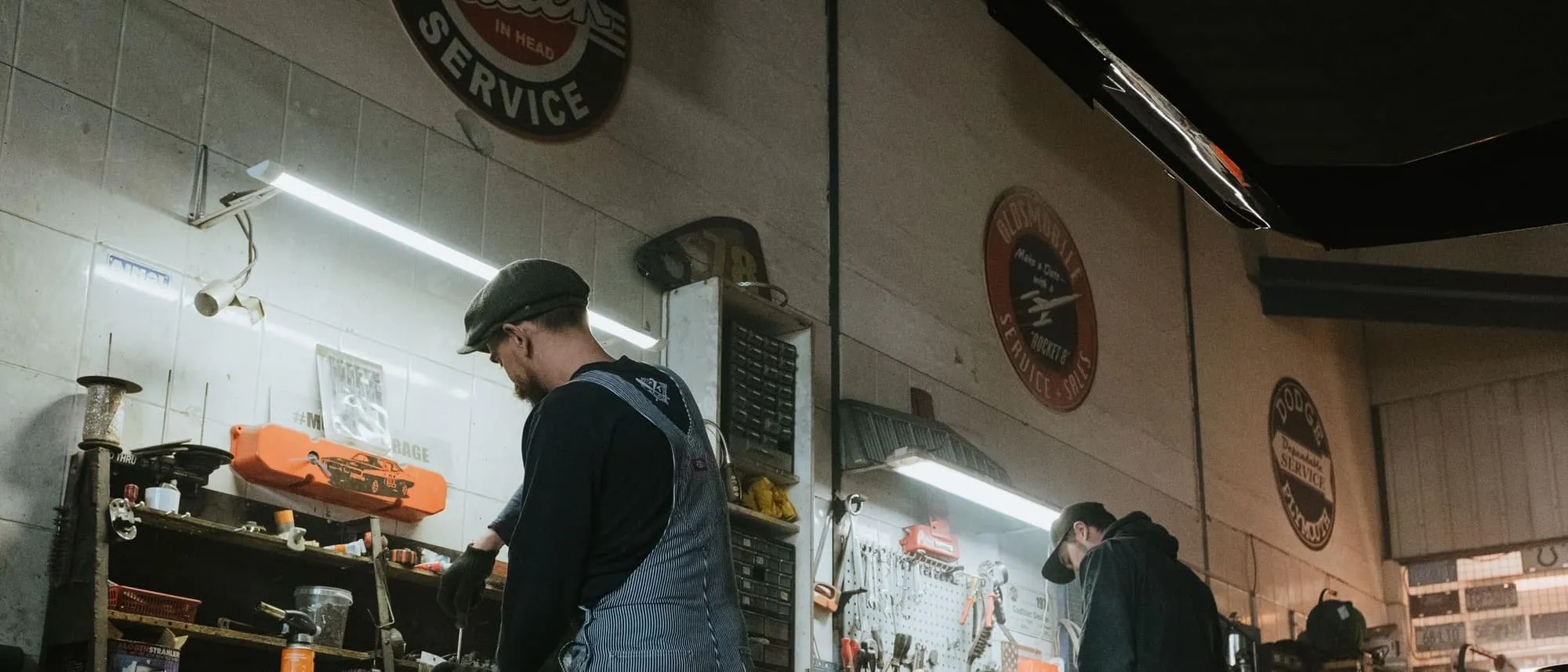 Two mechanics working together on a vehicle in a garage