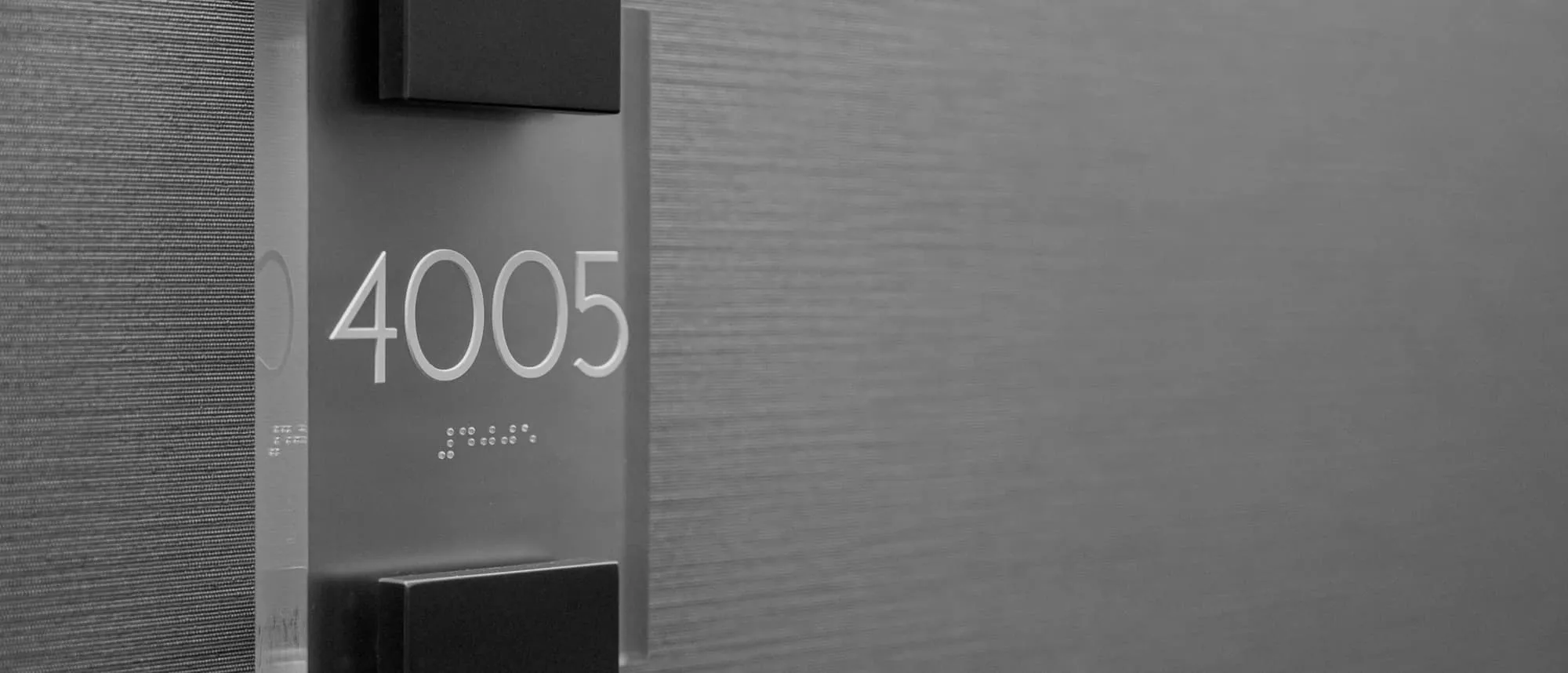 An illuminated room number sign with Braille beneath the numerals