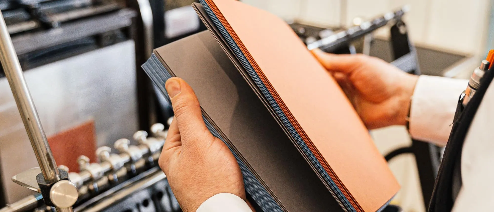 Freshly printed sheets being lifted from a press in a print workshop