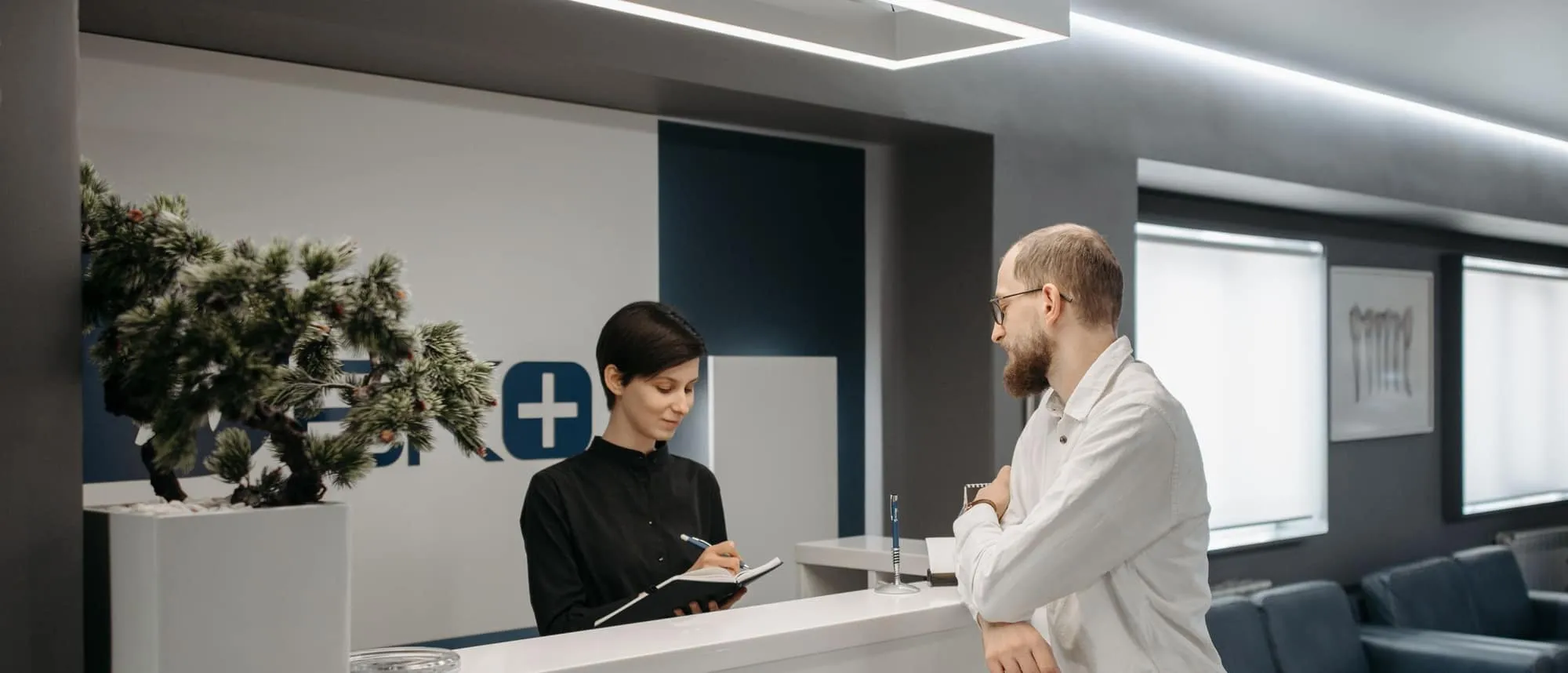 A patient being helped at a clinic reception desk