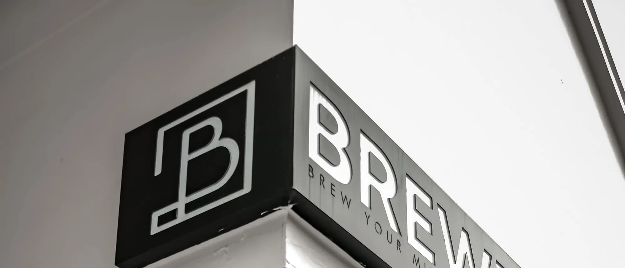 A projecting blade sign with a logo box mounted on a building corner