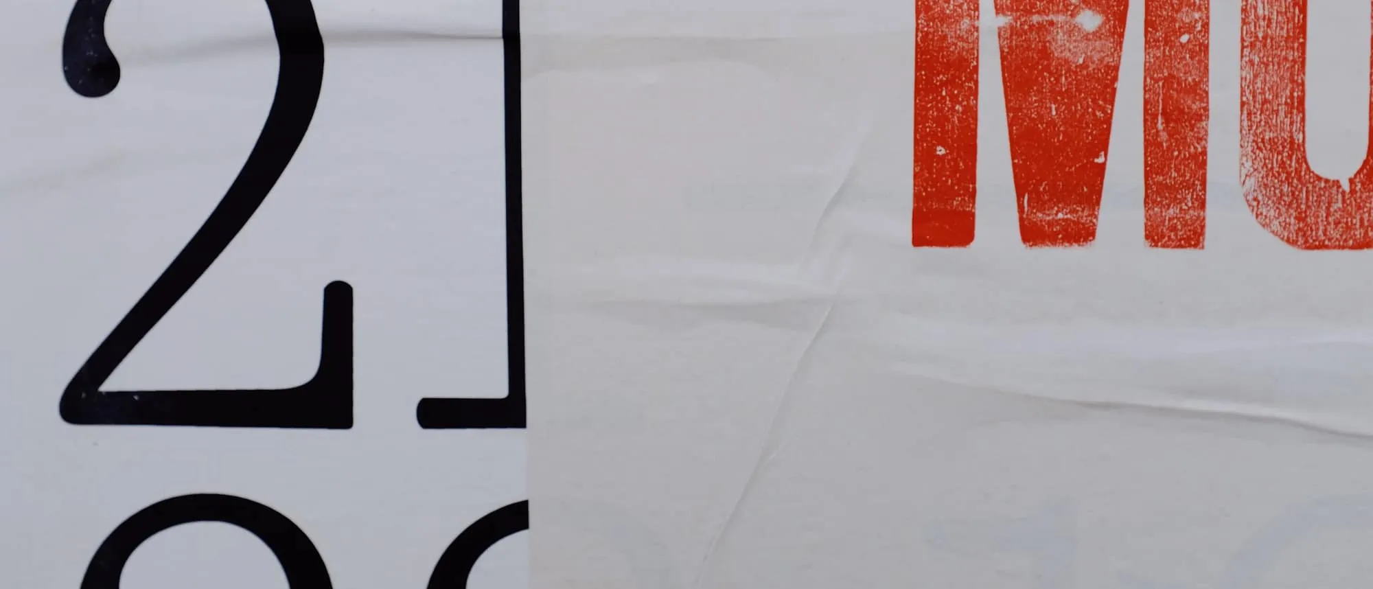 Printed lettering on a tensioned banner fixed to a building
