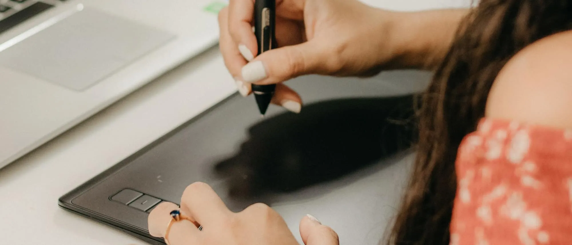 A designer working on layouts with a graphics tablet and laptop