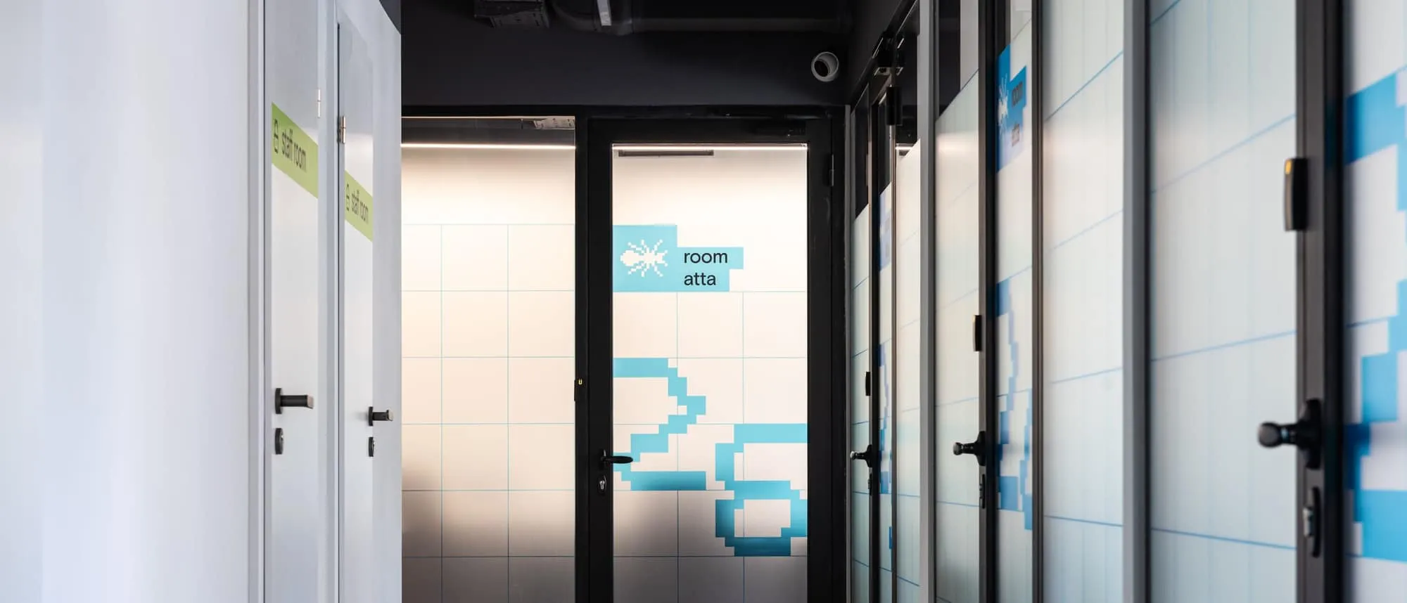 An office corridor with room signs and window graphics