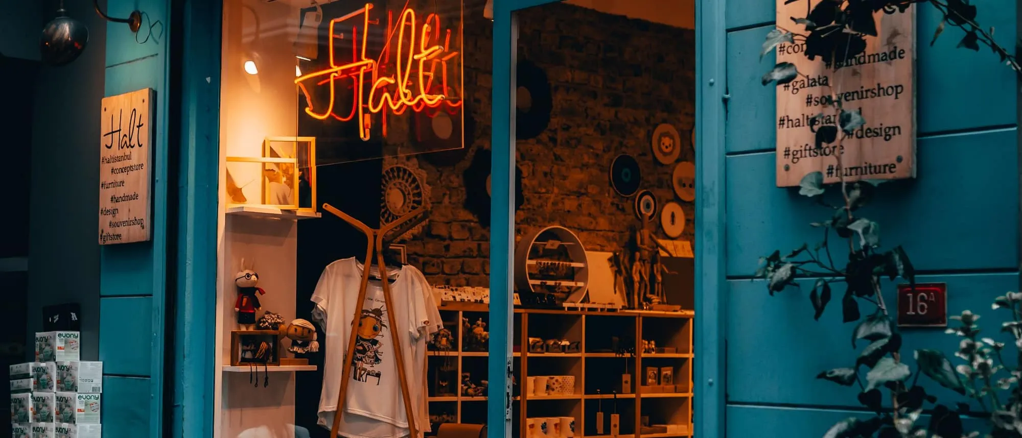 A lit LED sign glowing in a boutique window at night