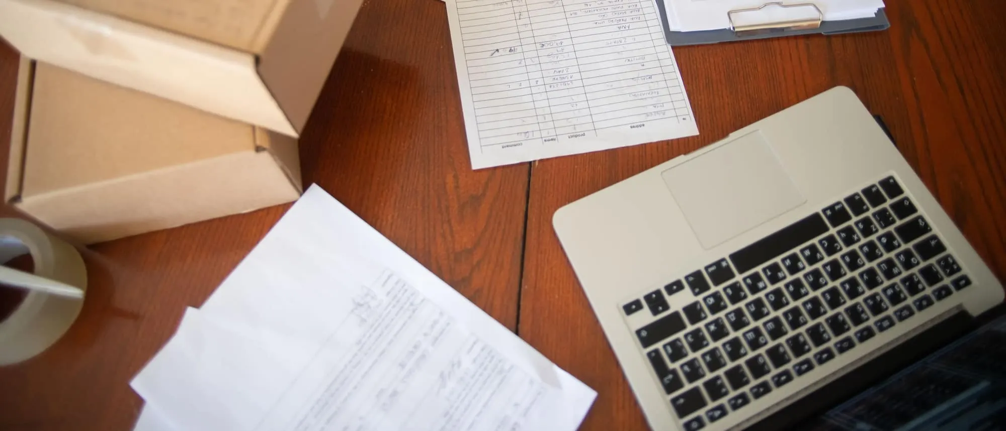 Printed documents and a laptop arranged on a desk