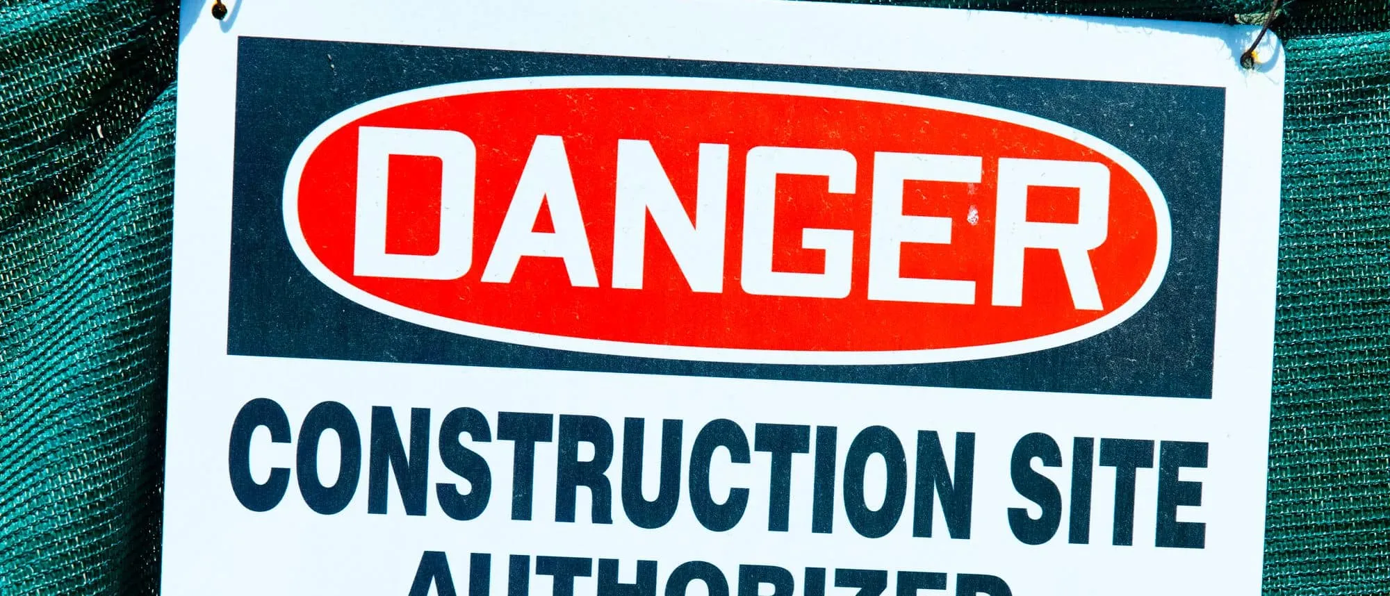 A danger warning sign on a construction site hoarding