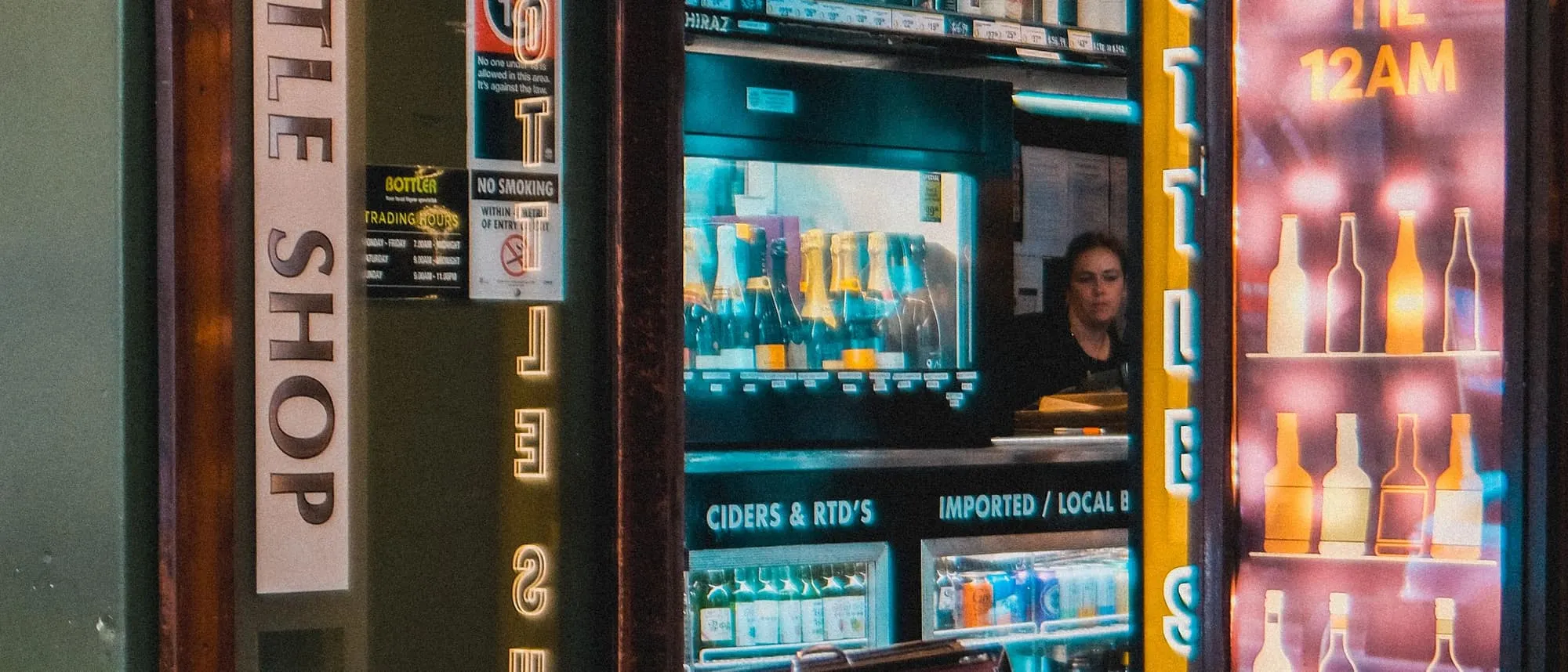 An illuminated shopfront sign photographed after dark