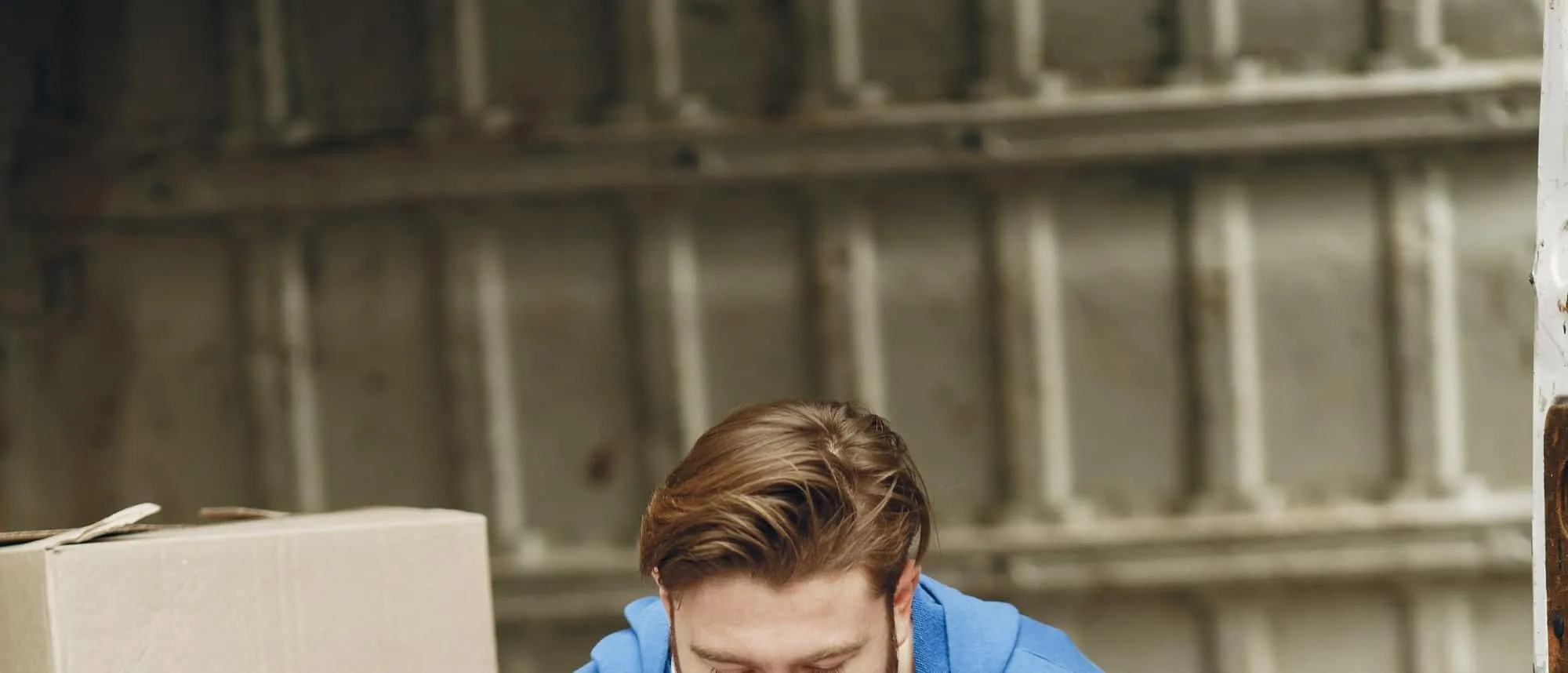 A warehouse worker checking stock beside a delivery van