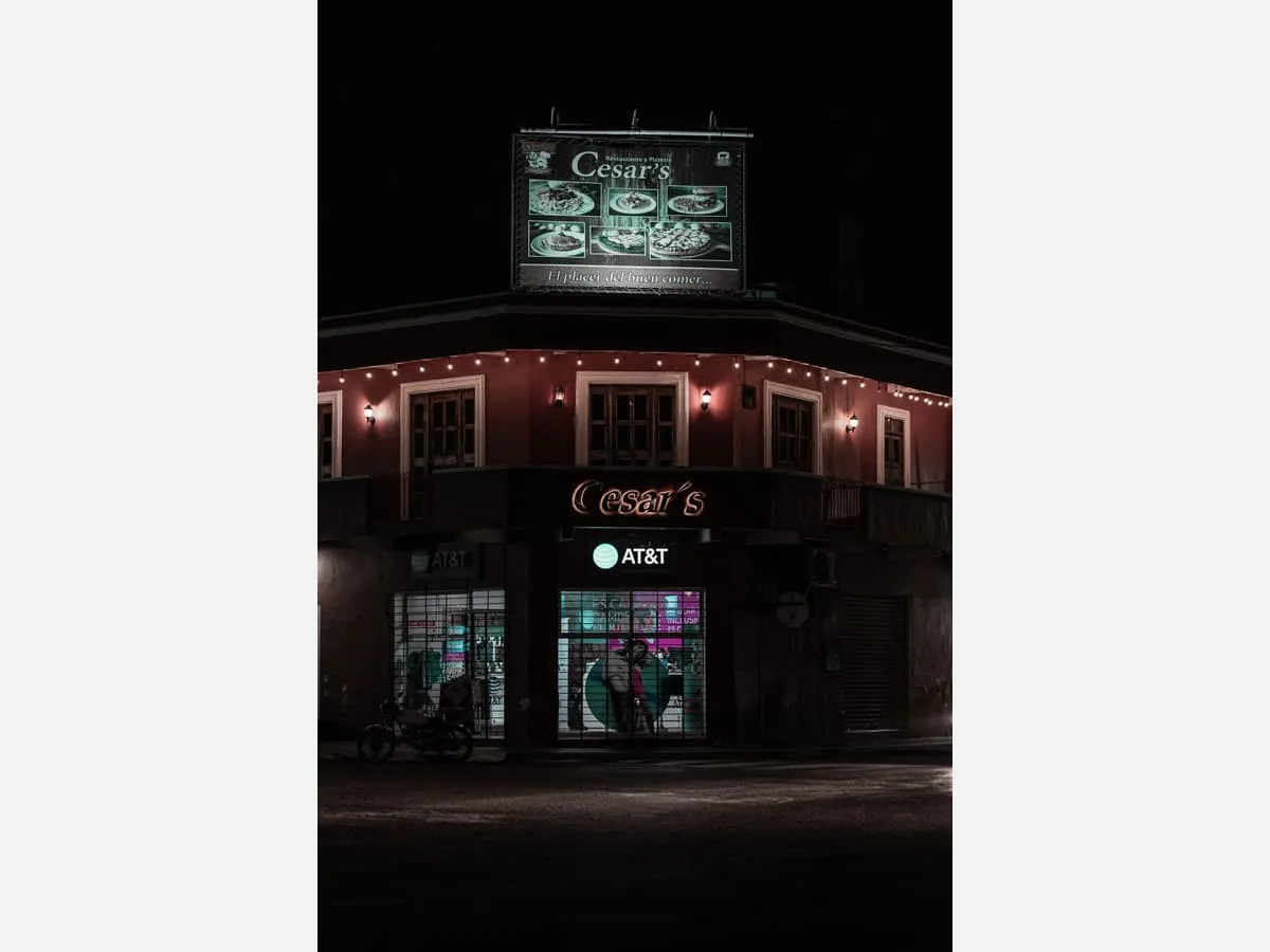 An illuminated sign on a building parapet at night