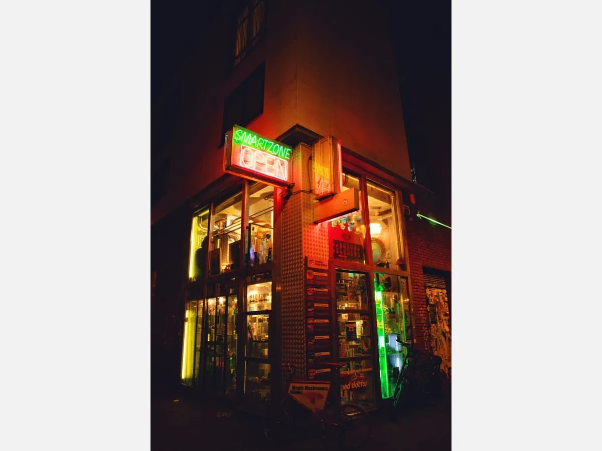An illuminated shopfront sign lit against a dark street