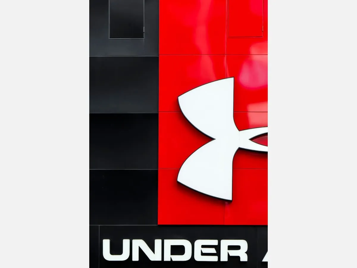 A dimensional company logo mounted on a dark reception panel