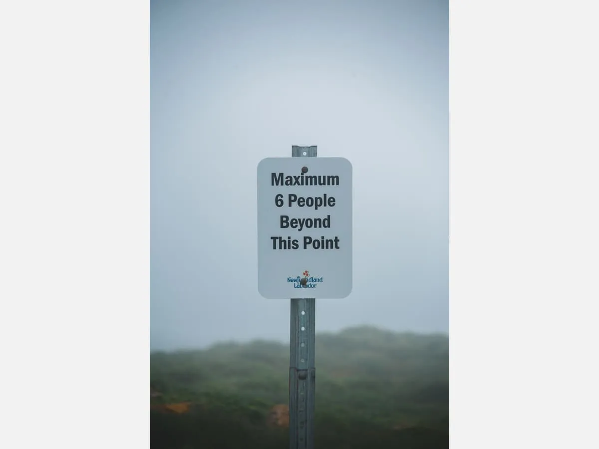 A wall-mounted sign stating a maximum occupancy limit